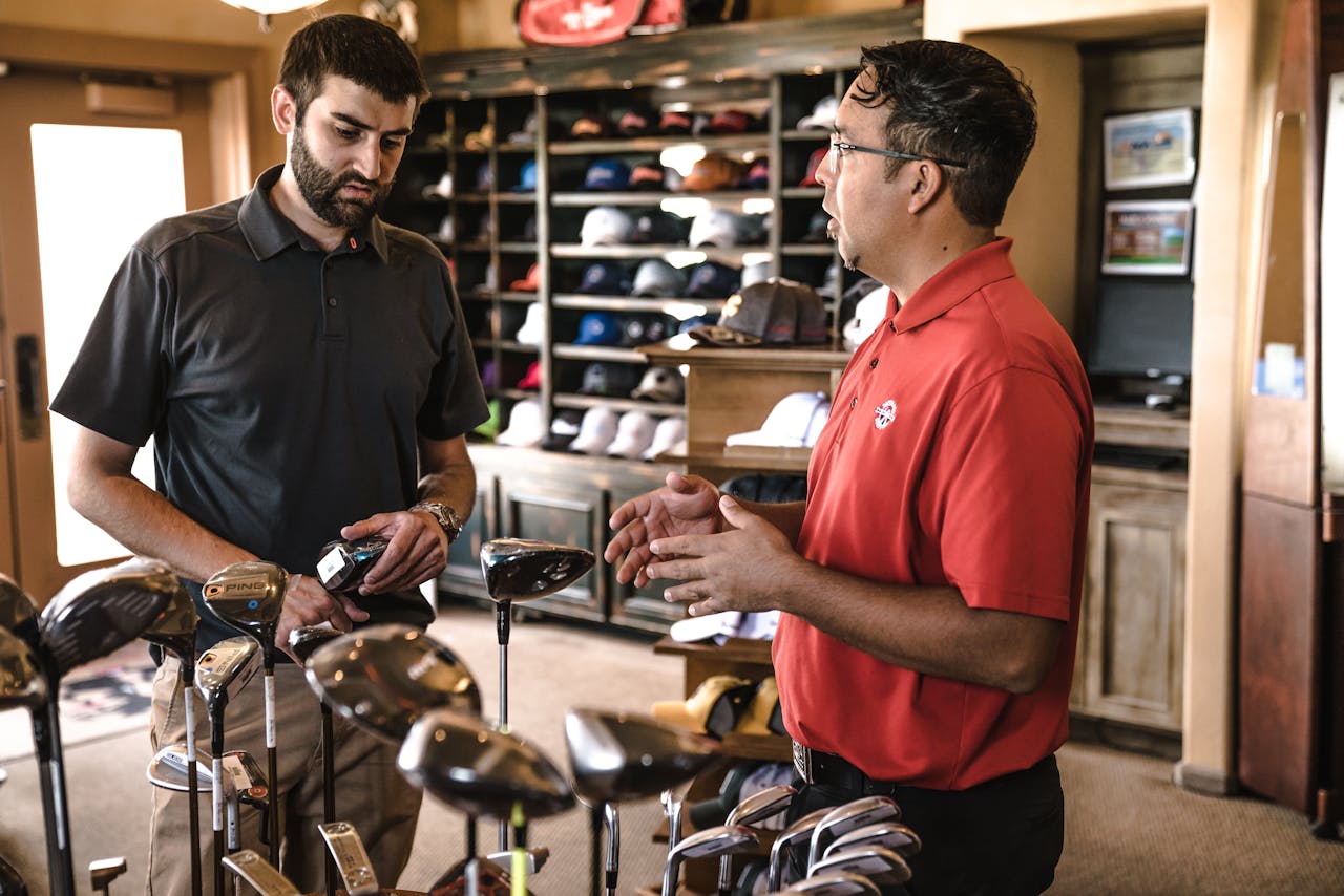 services-02 Customer receiving expert advice from salesman on golf equipment in a store.