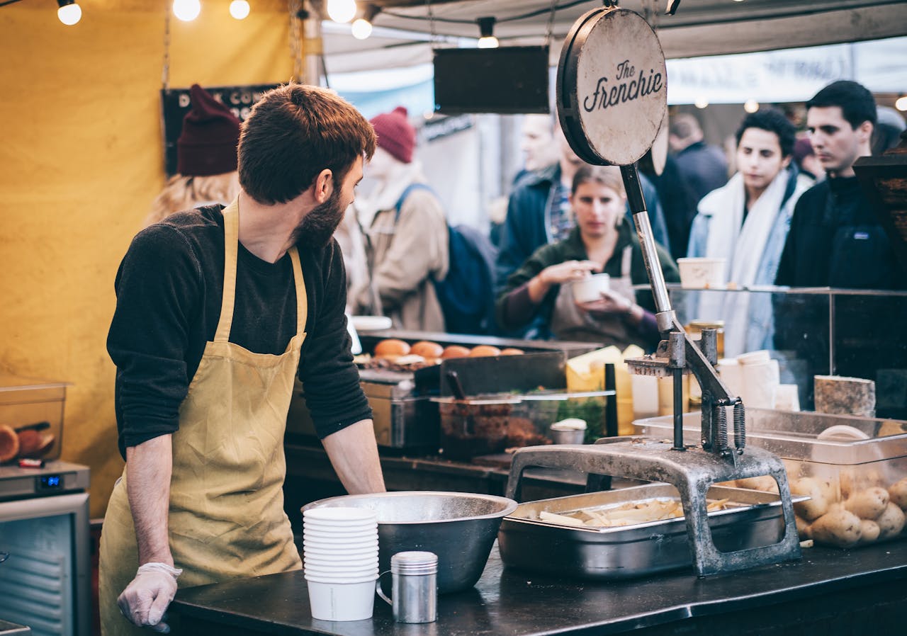 gallery-06 Dynamic scene of a street food vendor working in a busy market, engaging with diverse customers.